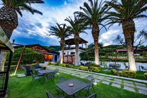 皮佐的住宿－索拉戈博爾戈Il酒店，一个带桌椅的庭院,棕榈树