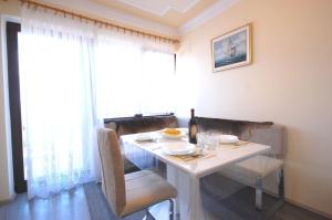 a white dining room table with a bottle of wine at Apartment Poljak Njivice in Njivice