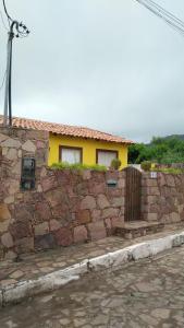 eine Backsteinmauer mit einem Haus im Hintergrund in der Unterkunft O Pouso Condomínio in Mucugê