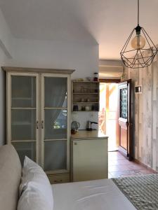 a bedroom with a white bed and a kitchen at Niriides in Ammouliani