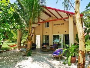 een huis aan het strand met een palmboom bij Paradise Villas Koh Rong Sanloem in Koh Rong Sanloem