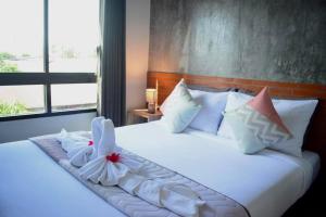 - une chambre avec un lit doté de draps et d'oreillers blancs dans l'établissement Isayarada Apartment, à Thalang