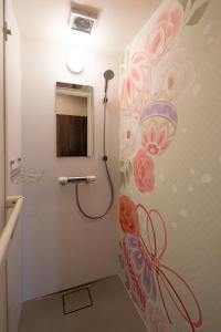 uma casa de banho com um chuveiro e um mural de flores na parede em Guesthouse kukuru em Wakayama
