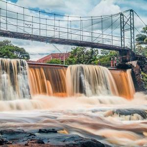 una imagen de una cascada con un puente sobre ella en Casarão Hotel en Brotas