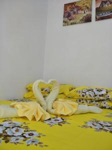 Una cama con una manta amarilla con cisnes. en Zhamira Avior's Condominium en Isla de Mactán