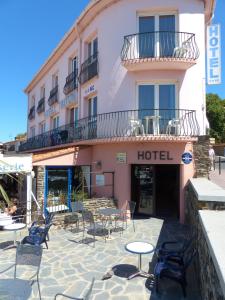 a hotel with tables and chairs in front of it at Hôtel Triton in Collioure