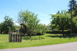 um parque infantil num parque com uma árvore em LA ROULOTTE DES AMISH & Bain Nordique à Remous Jacuzzi em Mattexey