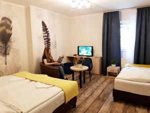 a woman sitting in a chair in a hotel room at Erdővarázs Panzió in Lillafüred