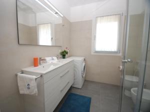 a bathroom with a sink and a toilet and a mirror at Due Perle in Lignano Sabbiadoro