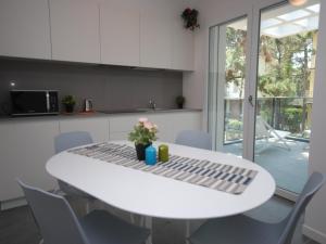 a white table in a kitchen with chairs and a table at Due Perle in Lignano Sabbiadoro