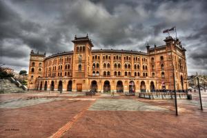 un grand bâtiment en briques avec un drapeau en haut dans l'établissement Ever House - ALCALA CIELO 1 ROOFTOP, à Madrid