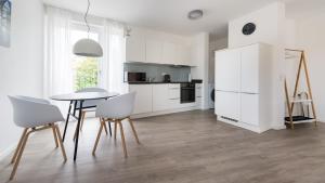 a kitchen with white cabinets and a table and chairs at Ferienwohnung Universität in Tübingen