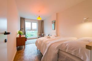 zwei Betten in einem Zimmer mit Fenster in der Unterkunft Vintage Duplex in Bruges in Brügge