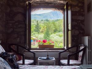1 Schlafzimmer mit 2 Stühlen und einem Fenster mit Aussicht in der Unterkunft Villa de Luccheri in Frasso Telesino