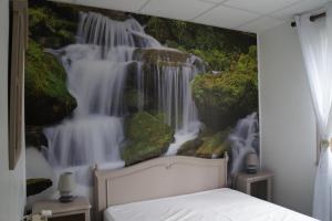 a bedroom with a waterfall mural on the wall at Chalet Plaisir- la nature in Uvernet