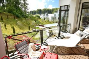 a balcony with chairs and a view of a pool at Luxus Apartment MeerFreude in Ostseebad Sellin