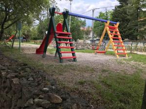 a playground with a slide and a monkey ladder at Apartman Dora in Šmrika