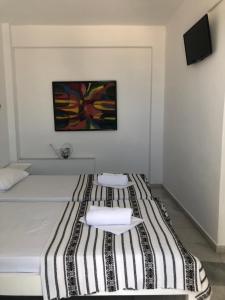 1 cama con 2 almohadas y una pintura en la pared en Sigma Studios on The Beach, en Naxos Chora