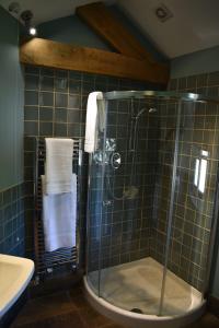 a bathroom with a glass shower and a sink at Burnhaies Farm Coach House in Cullompton