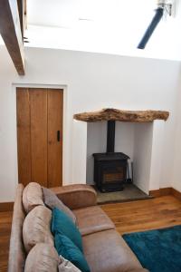 a living room with a couch and a wood stove at Burnhaies Farm Coach House in Cullompton