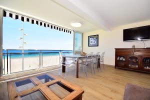 Un comedor con mesa y sillas y una gran ventana. en CL LUXURY APARTMENT FIRST LINE BEACH, en Benidorm