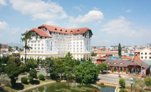 een groot wit gebouw met een rood dak bij Saigon Dalat Hotel in Da Lat