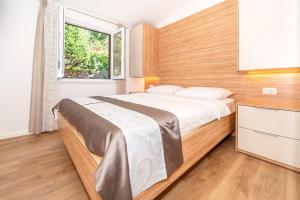 a bedroom with a large bed and a window at Apartments Kricin II in Baška