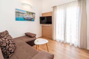 a living room with a couch and a tv at Apartments Kricin II in Baška