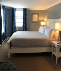 a bedroom with a large bed with blue curtains at Bellevue House in Newport