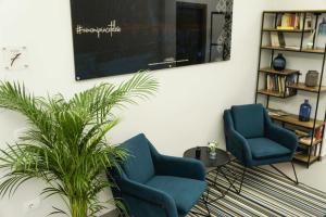 テレーゼにあるAlbergo D'Onofrioの- 植物のあるリビングルームの青い椅子2脚