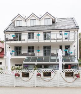 a white fence in front of a building at Rafa przy Plaży in Sztutowo