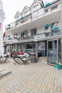 a patio with chairs and tables in front of a building at Rafa przy Plaży in Sztutowo