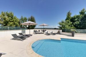 - une piscine avec des chaises longues et des parasols à côté dans l'établissement Relais du Bas Limousin, à Sadroc