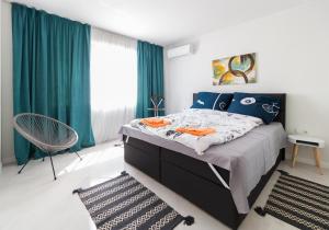 a bedroom with a large bed with blue curtains at Pop your COLORS - Funky and Modern 1BDR Apt by Flat Mаnager in Plovdiv