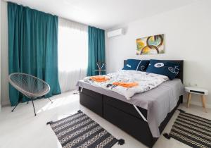 a bedroom with a large bed with blue curtains at Pop your C-O-L-O-R-S - Funky and Modern 1BDR. Apt. in Plovdiv