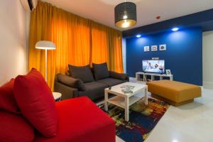 a living room with a red couch and a tv at Pop your COLORS - Funky and Modern 1BDR Apt by Flat Mаnager in Plovdiv