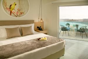 a bedroom with a bed with a tray of food on it at NissiBlu Beach Resort in Ayia Napa