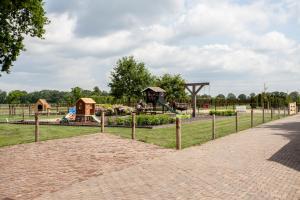 een park met een speeltuin en een speeltuin bij De Wijnlodge in Kootwijkerbroek