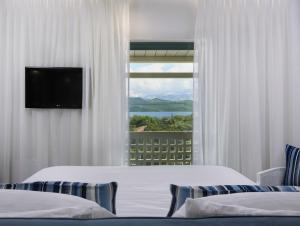 ニキアナにあるThomais Boutique Hotelのベッドが2つと窓があるホテルの部屋