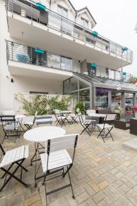 a patio with tables and chairs in front of a building at Rafa przy Plaży in Sztutowo