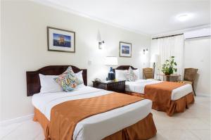 Un pat sau paturi într-o cameră la Bay Gardens Hotel
