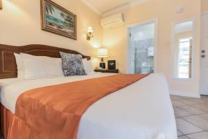 Un pat sau paturi într-o cameră la Bay Gardens Hotel