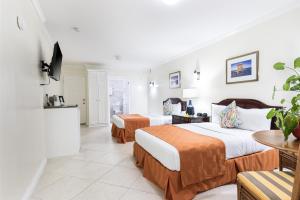 Un pat sau paturi într-o cameră la Bay Gardens Hotel