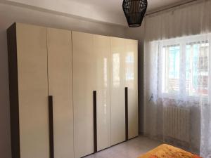 a bedroom with a large white cabinet and a window at Casa Sarahouse in Taranto