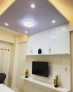 uma sala de estar com uma televisão de ecrã plano na parede em The Windy Heights Tagaytay em Tagaytay