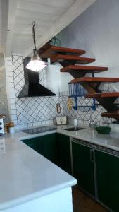 a kitchen with green cabinets and a light fixture at Vivienda rural fuente de los gusarapos in Burunchel