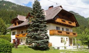 ein großes Haus mit einem Baum davor in der Unterkunft Apartment Gästehaus Wastian in Weissbriach