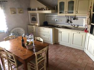 Una cocina con una mesa de madera con una botella de vino. en Antico Casale Silvia, en Alberoro