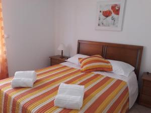 a bedroom with a bed with two towels on it at Casa da Zi in Vila Nova de Milfontes