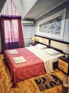 una camera da letto con un grande letto con una coperta rossa di B&B Europa Hotel a Kutaisi